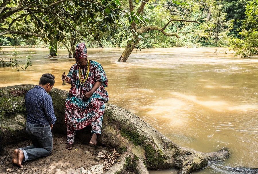 The priest of Osun performs a blessing for Jumoke Sanwo on the banks of the Osun river. c. CyArk 