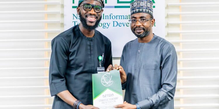 Google West Africa Director, Olumide Balogun, and the Director General, National Information Technology Development Agency (NITDA), Kashifu Inuwa, CCIE, while presenting the former with NITDA'S Strategic RoadMap and Action Plan (SRAP) document, during a visit to NITDA'S corporate headquarters, in Abuja