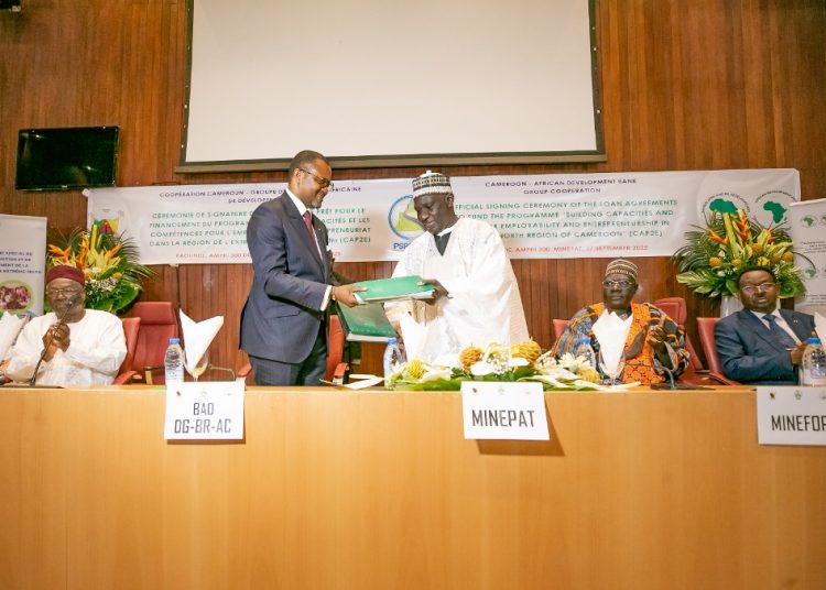 Mey and Bassolé exchange documents after signing the agreements